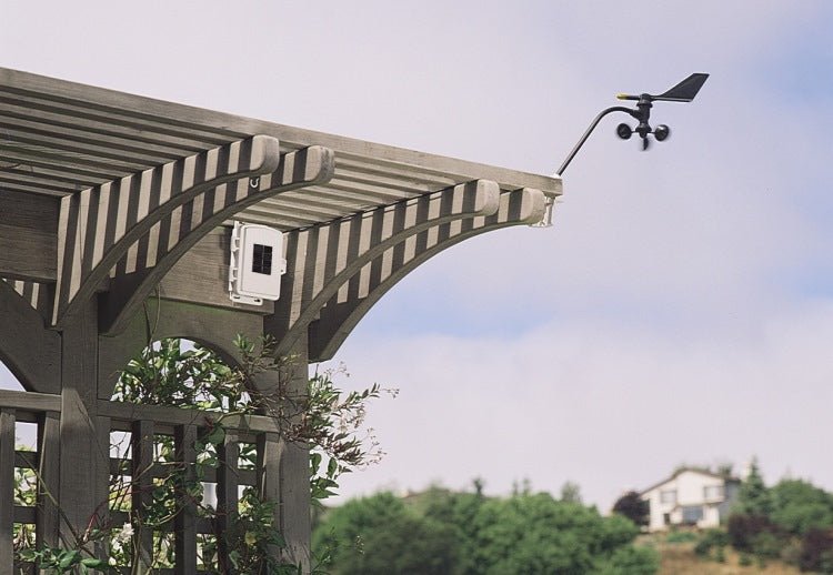 solar-powered wireless sensor transmitter mounted outdoors with anemometer